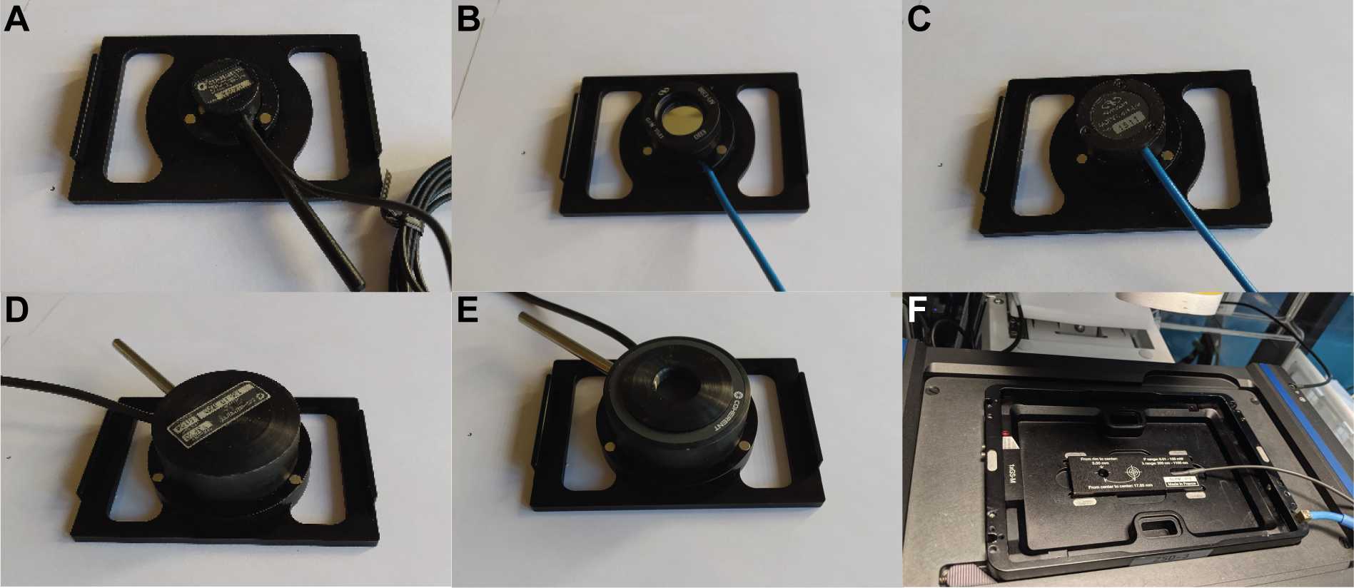 Figure 2. Examples of power sensor holders. Computer Numerical Control (CNC) machined holders in multi-well size for use in upright or inverted microscope configuration for A) inverted and B) upright Coherent LM-2 VIS and C) inverted Newport 840 sensor model 818C, D) inverted and E) upright Coherent LM-10 HT power sensors and F) commercial slide holder (Oko Lab) for the Argo-Power (Argolight) power meter sensor. Figure 2. Examples of power sensor holders. Computer Numerical Control (CNC) machined holders in multi-well size for use in upright or inverted microscope configuration for A) inverted and B) upright Coherent LM-2 VIS and C) inverted Newport 840 sensor model 818C, D) inverted and E) upright Coherent LM-10 HT power sensors and F) commercial slide holder (Oko Lab) for the Argo-Power (Argolight) power meter sensor.
