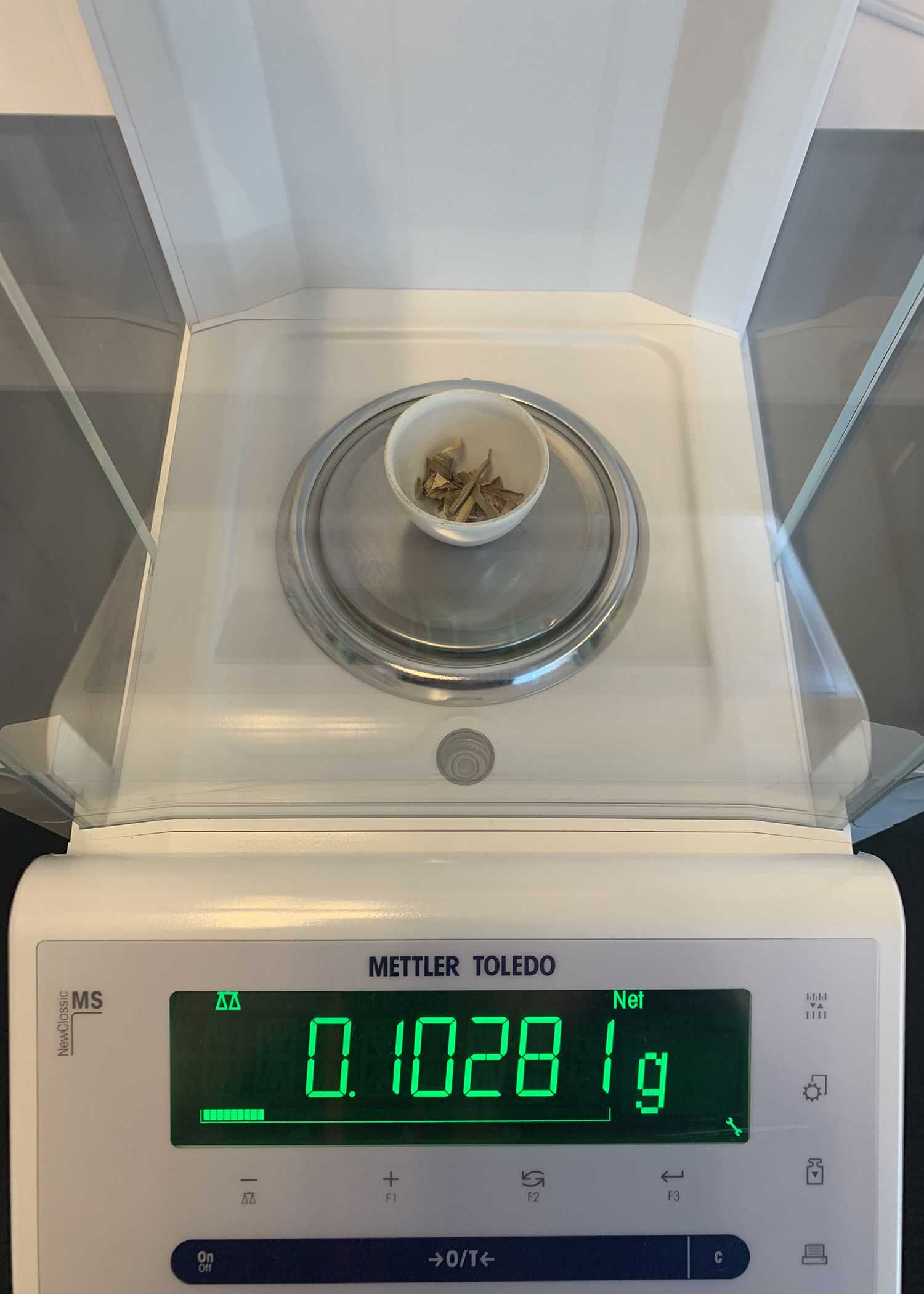 Plant material weighed with a precision scale inside the ceramic crucible. Plant material weighed with a precision scale inside the ceramic crucible.
