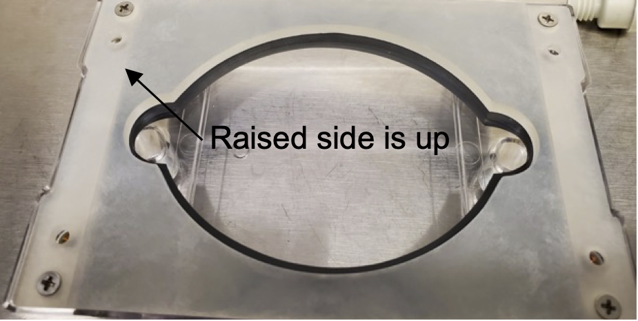 Fig. 6: Backing plate screwed to the base with the raised side facing away from the glass slide Fig. 6: Backing plate screwed to the base with the raised side facing away from the glass slide